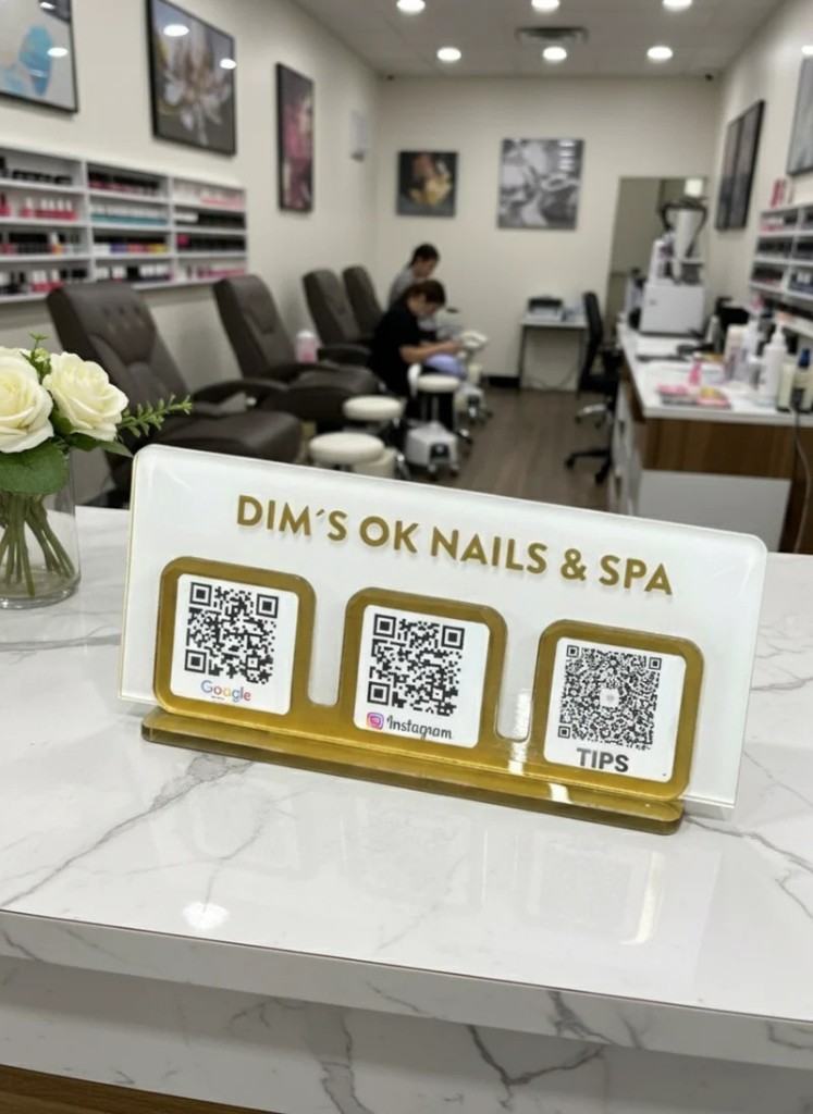 TapMeGo display stand with gold QR frames in a nail salon